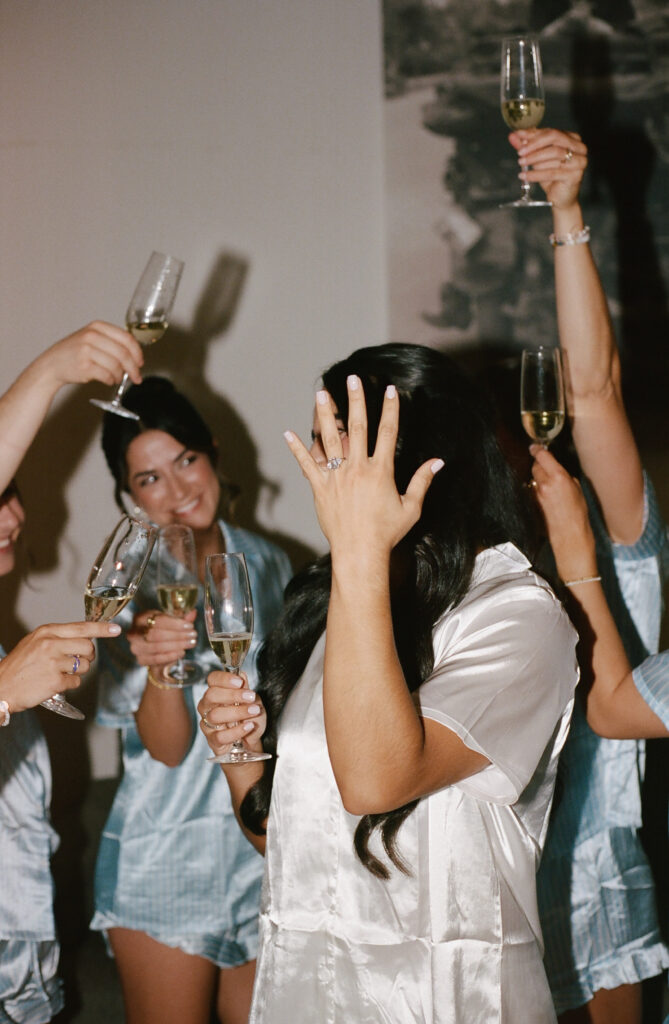 Bride celebrating with friends while holding a champagne glass before ceremony