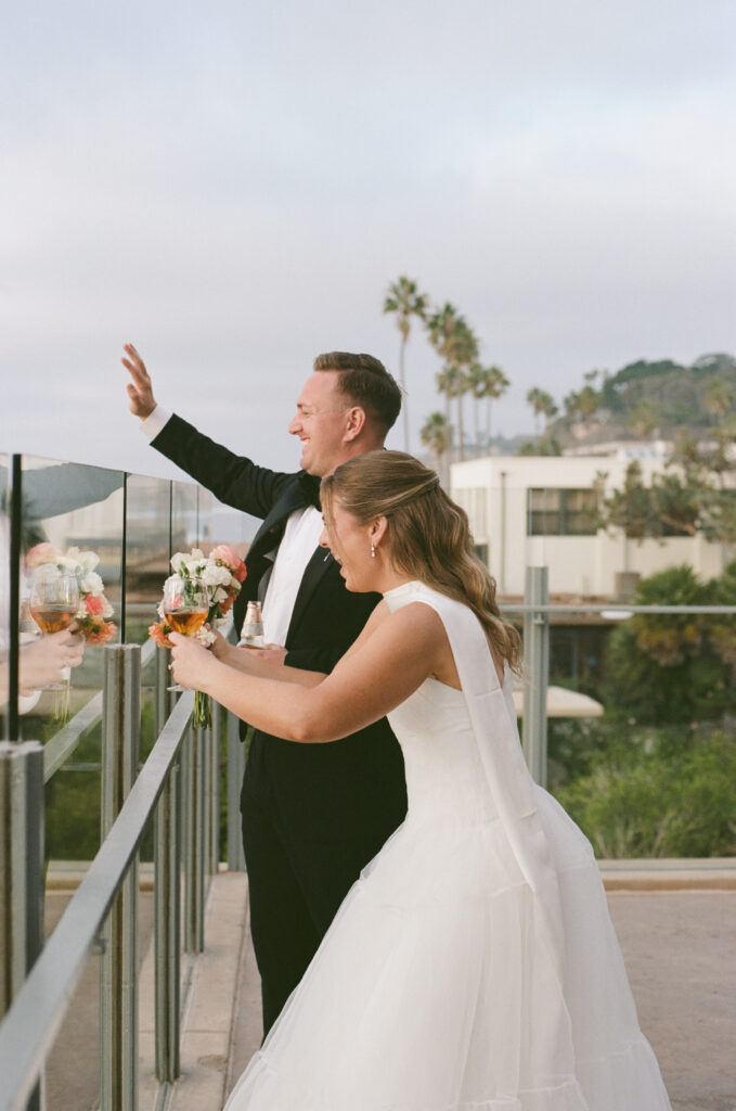 Film photograph of Ben and Lauren celebrating with cocktails at their La Jolla wedding