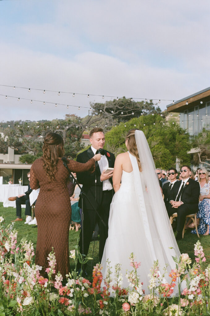 Film photograph of Ben and Lauren exchanging vows surrounded by wedding guests