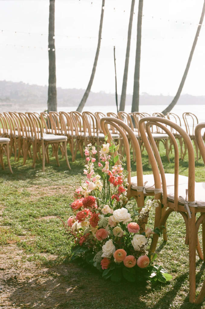 Film photograph of floral wedding ceremony arrangements overlooking the Pacific Ocean