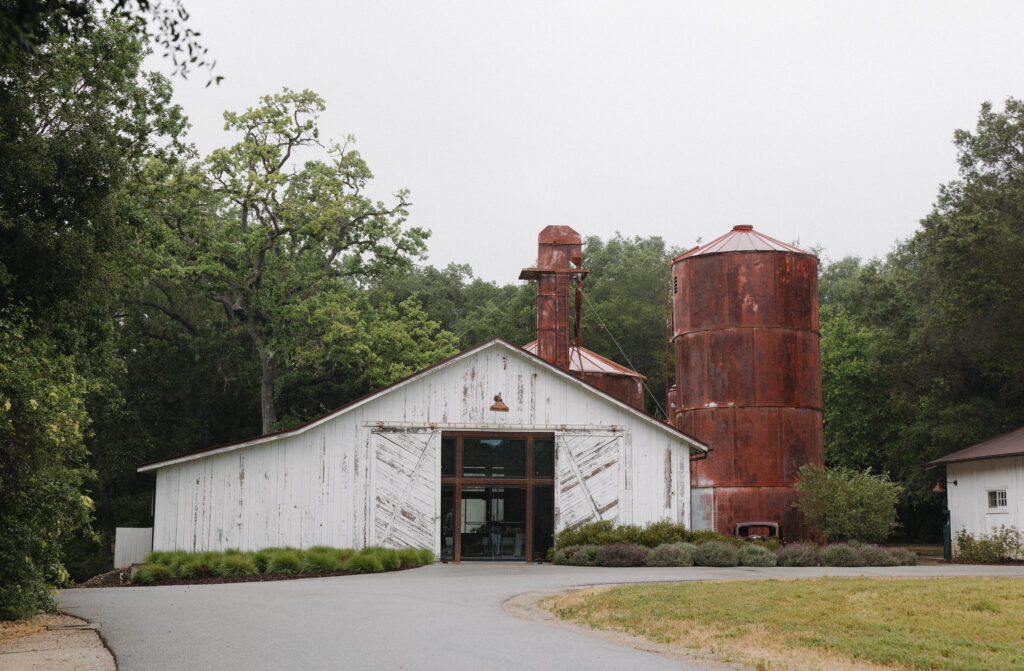 Halter Ranch barn exterior surrounded by trees on a rainy spring wedding day in Paso Robles