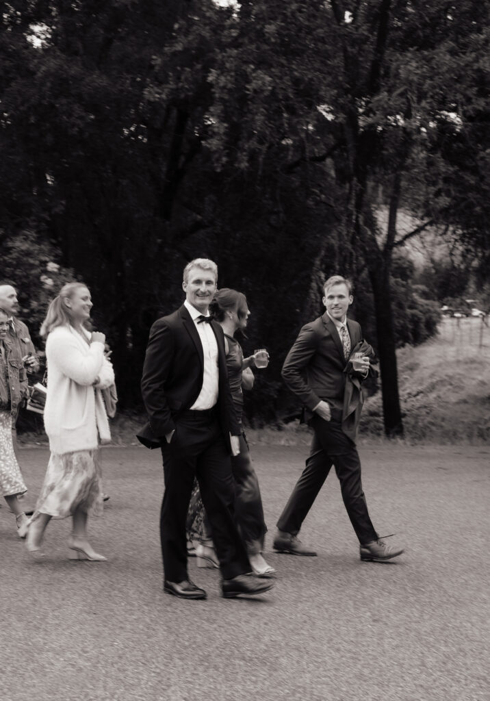 Black-and-white photo of wedding guests walking together outside Halter Ranch