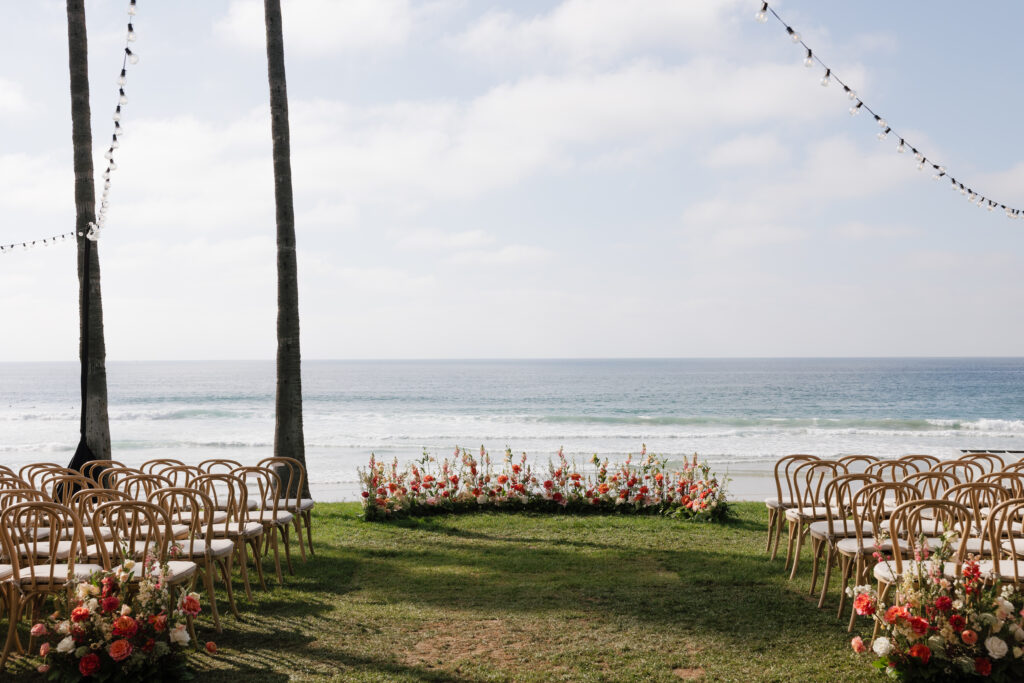 California coast wedding ceremony setup with floral arrangements and ocean views