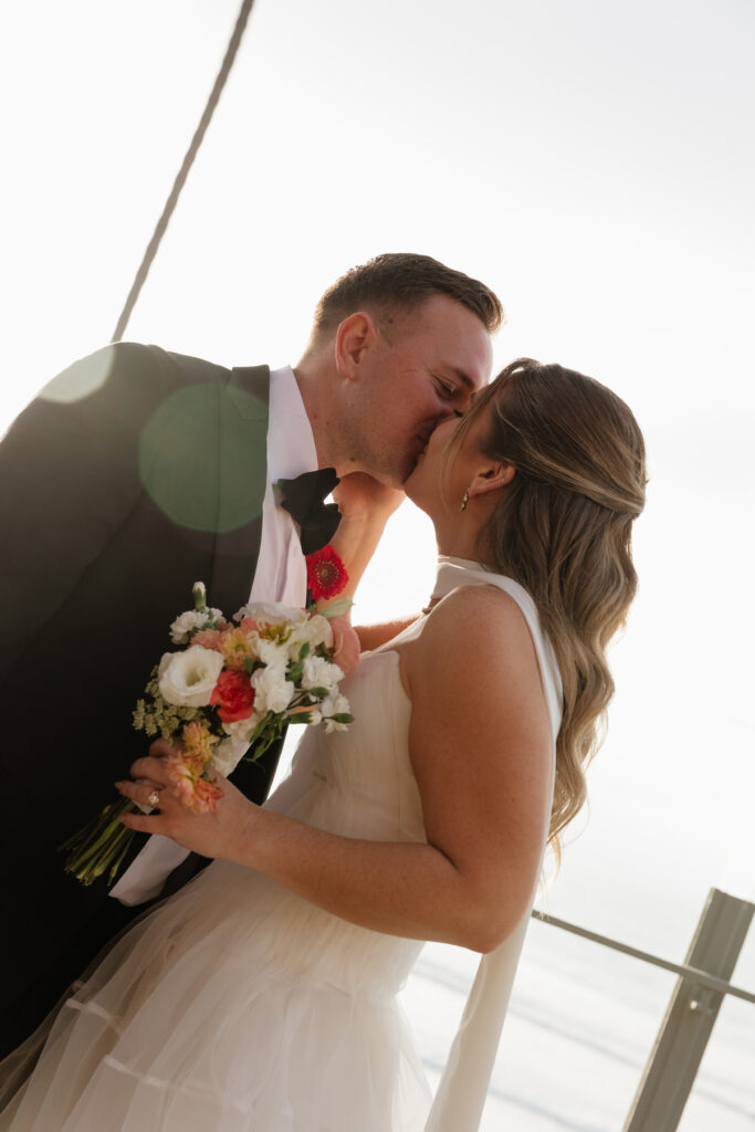 Ben kissing Lauren during a romantic Scripps Seaside Forum wedding portrait