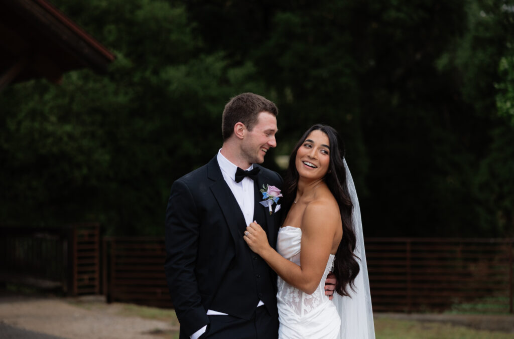 Bride and groom smiling together beneath the covered bridge at their Halter Ranch wedding