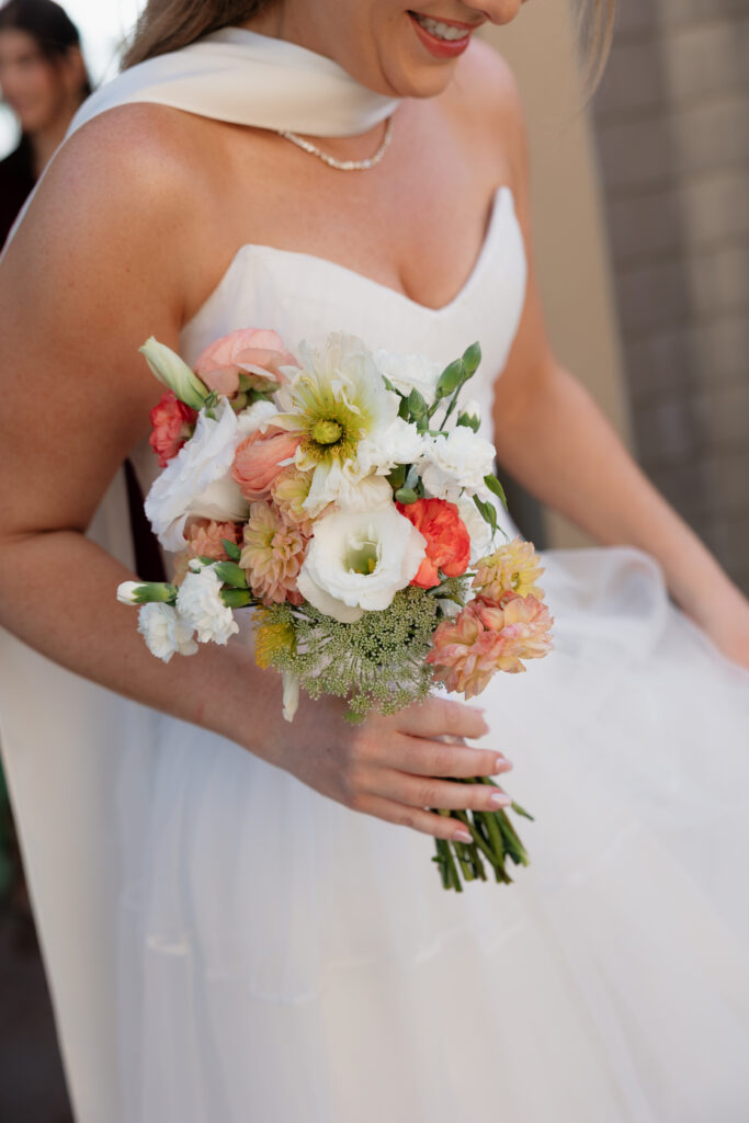 Bride holding a colorful floral bouquet during her Scripps Seaside Forum wedding