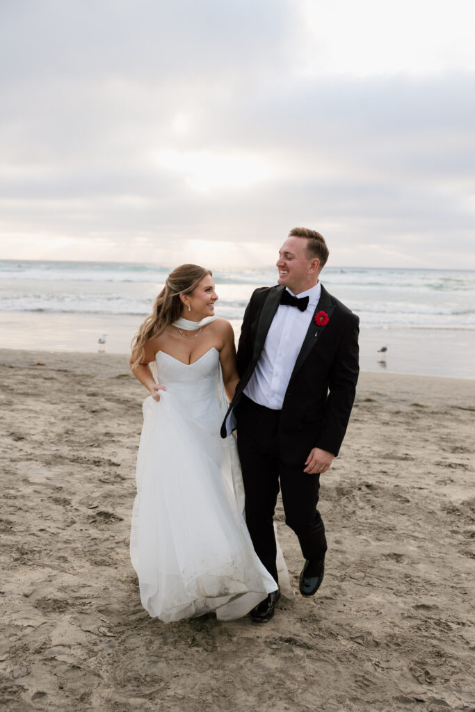 Newlyweds smiling together during their Scripps Seaside Forum wedding portraits