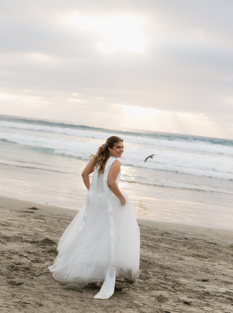 Lauren walking along the beach in her flowing wedding dress