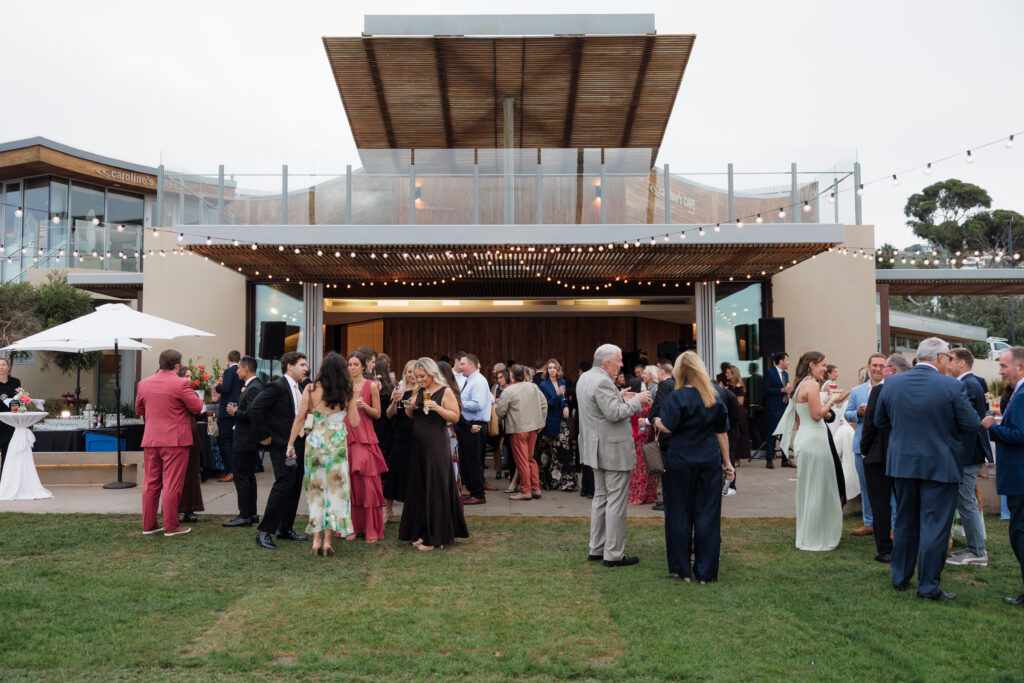 Wedding guests gathering on the lawn at Scripps Seaside Forum overlooking the Pacific Ocean
